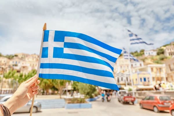 A student with a Greek flag overlooking the Acropolis in Athens